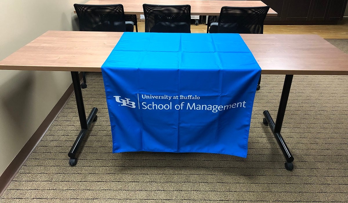 Zoom image: School of Management logo in white on a blue table runner.