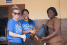 Samantha Podlas, MBA/MSW ’15, and Vazquez present a donated laptop to the Bawaleshie School in Ghana.