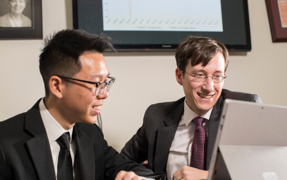 Michael Leung and Professor Dominik Roesch look over the undergrad’s stock trading strategy research. 