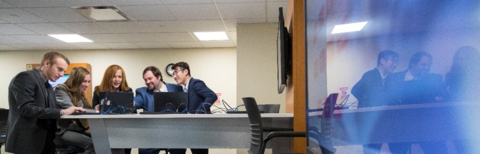 From left, Andrew Meyer, Megan Gramza, Professor Dianna Cichocki, Gabriel Gee and Pengbo Ma look over the team’s final deliverable for the Olmsted Center for Sight. 