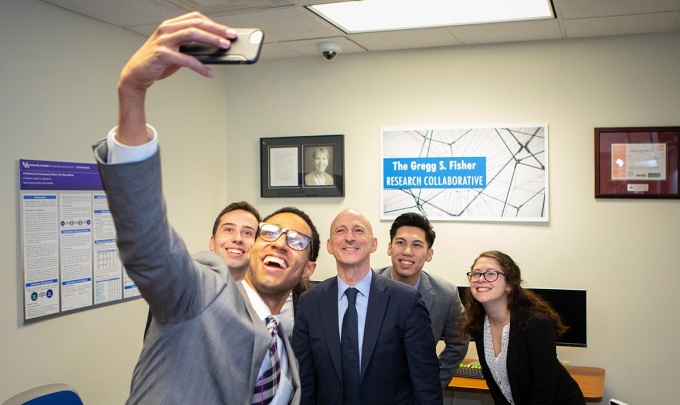 Fisher takes a selfie with students in the Fisher Research Collaborative at the UB School of Management. 