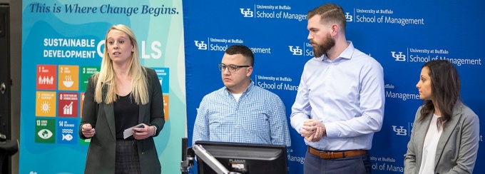 Students presenting their project at a lectern. Access a larger version of this image. 