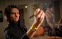 School of Management student Anu Patel writes on a board. Read the Startups section in this issue of Buffalo Business. 