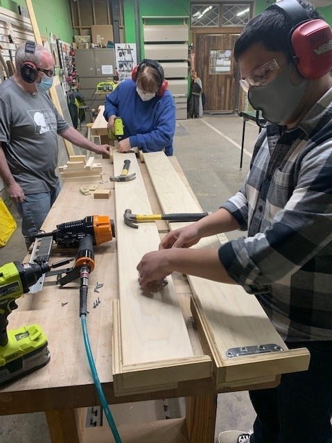 Zoom image: Service Collaborative of WNY volunteers help build twin-size beds for Beds for Buffalo. 