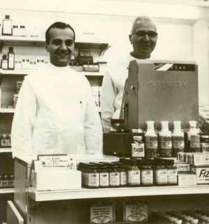 Henry Panasci Jr., and his father, Henry Panasci Sr., behind the counter at the first Fay's Drug Store in Syracuse, New York, in 1958. 