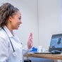 Physician has a telemedicine appointment with patient on screen. 