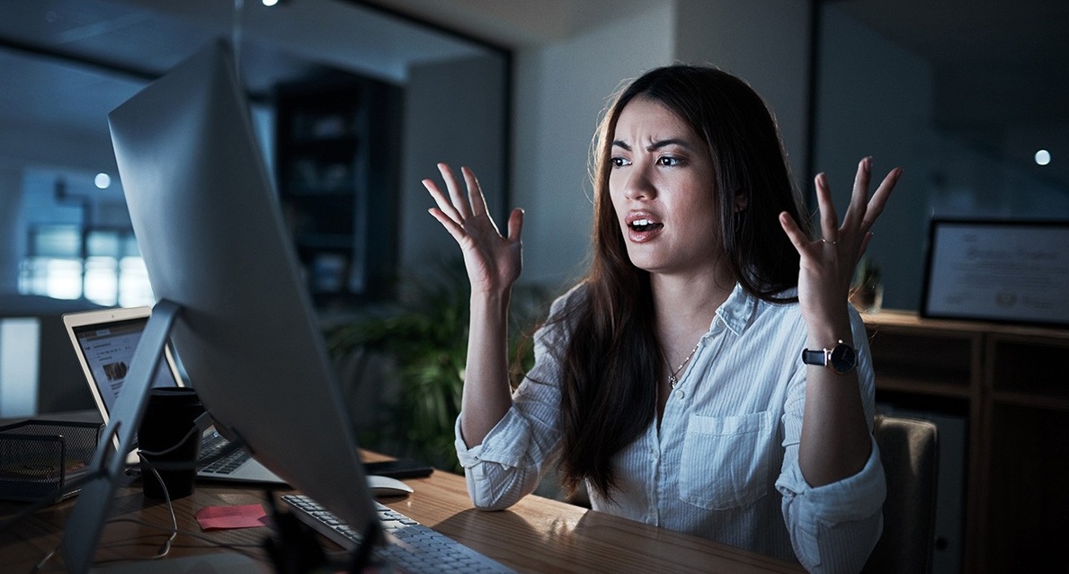 Woman at computer looking frustrated. 