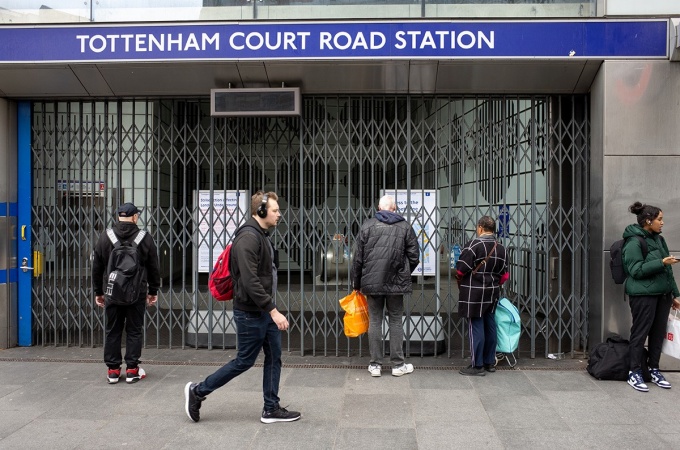 Commuters walk past a closed subway station in London. 