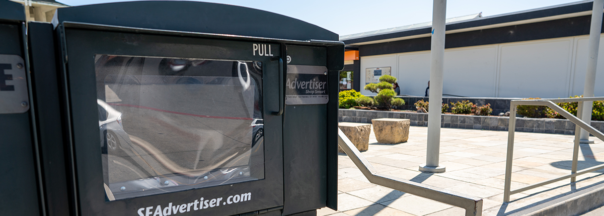 Empty newspaper box that reads SFAdvertiser.com. 