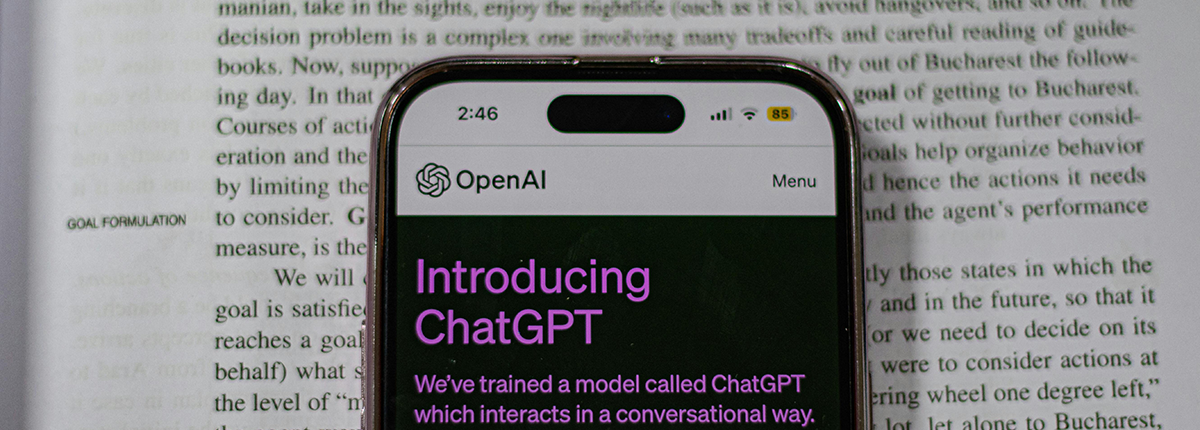 Phone showing ChatGPT on top of a textbook. 