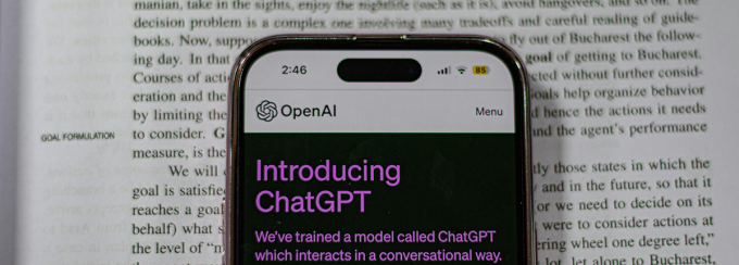 Phone showing ChatGPT on top of a textbook. 