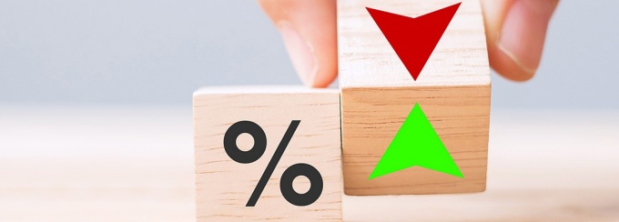 Two dice: one with a percentage symbol and one with up and down arrows. 