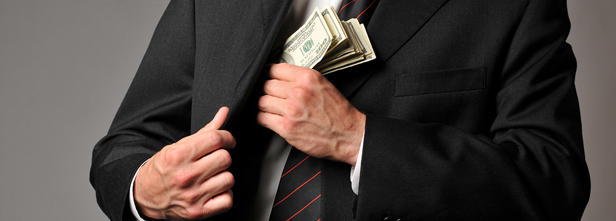 Man stuffing cash into suit pocket. 