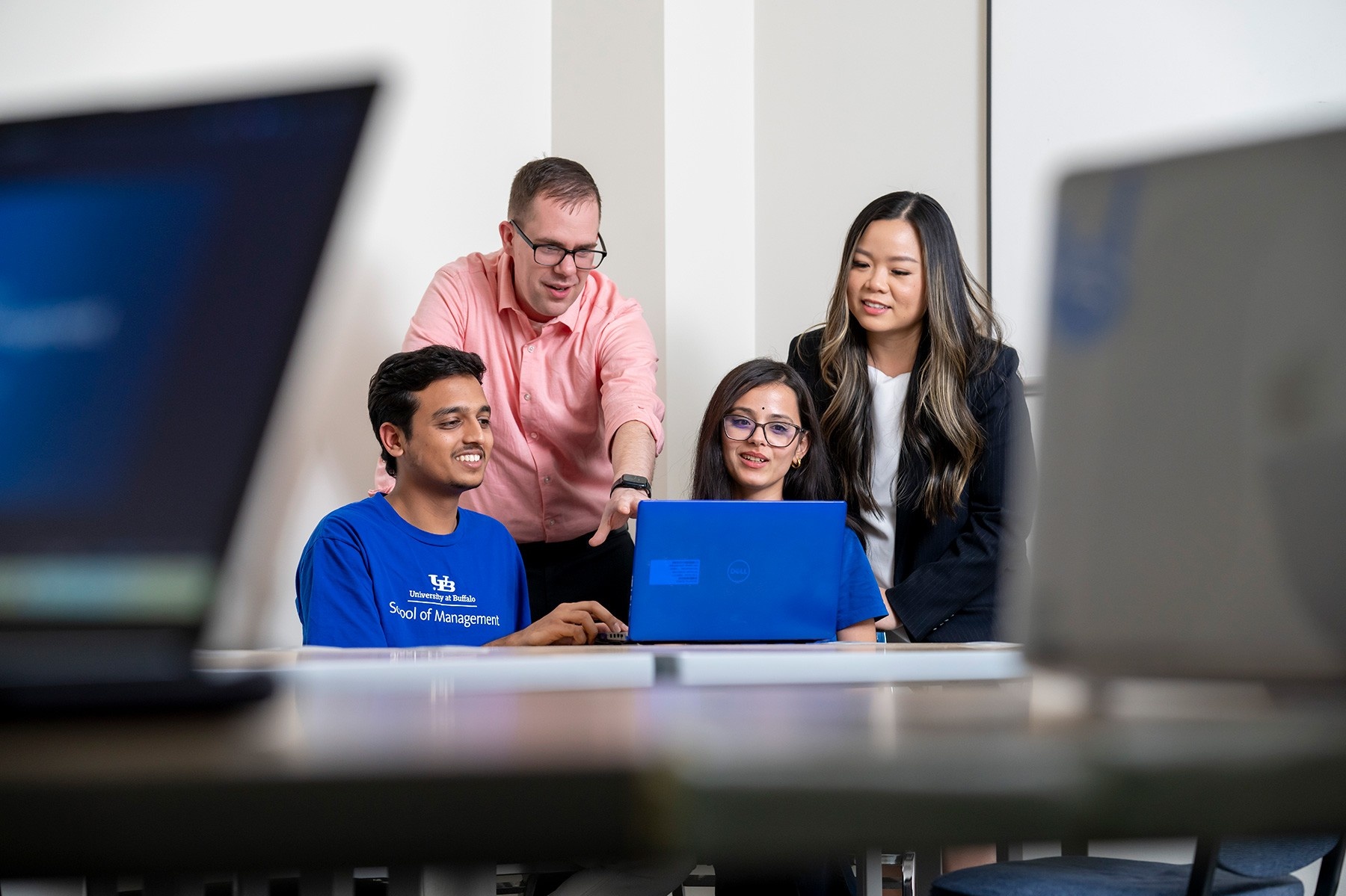 Zoom image: Professors Michael Krupski and Cassie Nguyen with graduate students Abhishek Harihar and Kavita Pant in the Projects Clinic space in Alfiero Center. Photo: Tom Wolf 