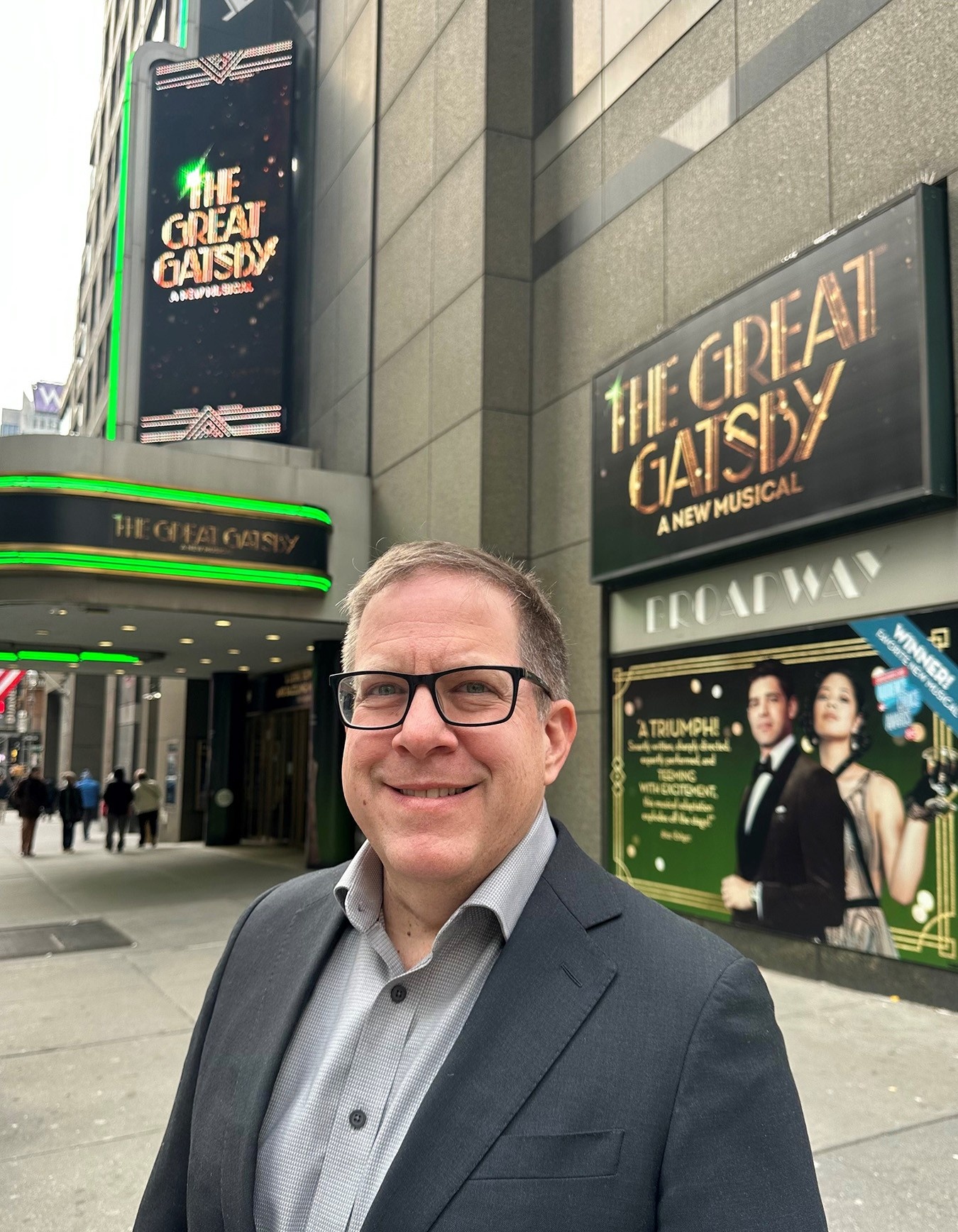 Zoom image: Mark Shacket, BS ’94, MBA ’95, in front of New York City’s Broadway Theatre. 