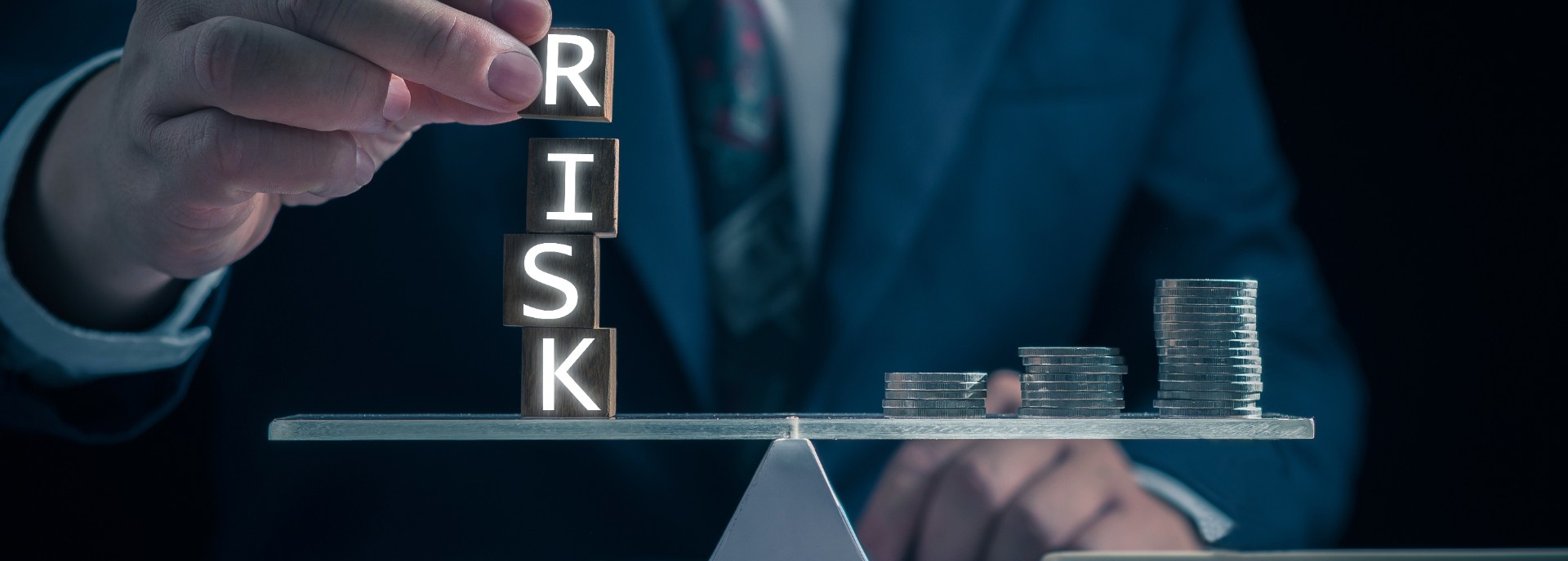 Balancing tiles spelling "risk" and money.