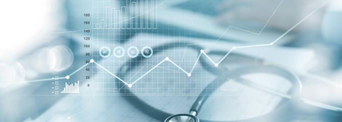 Stethoscope on a table with charts and graphs. 