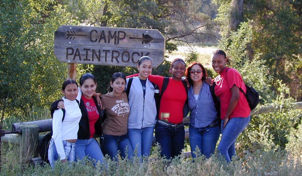 Students standing in front of road sign pointing to Camp Paintrock. 
