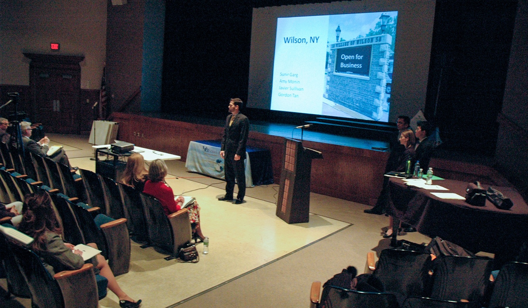 Student presenting a slideshow in an auditorium. 