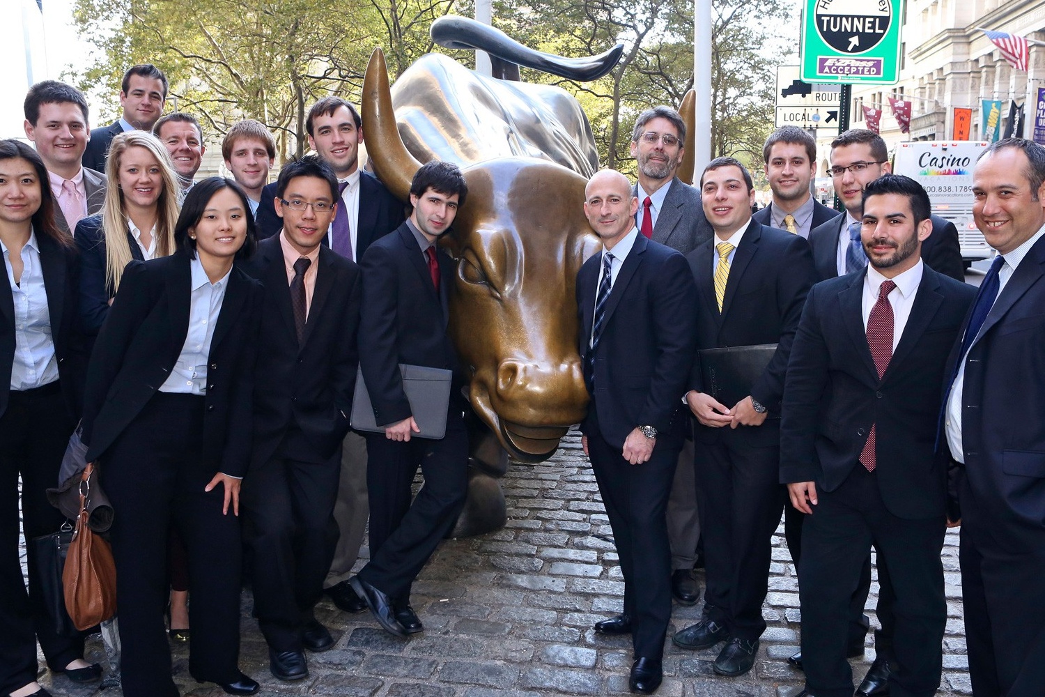 Students standing in front of the golden bull sculpture in Wall Street. 