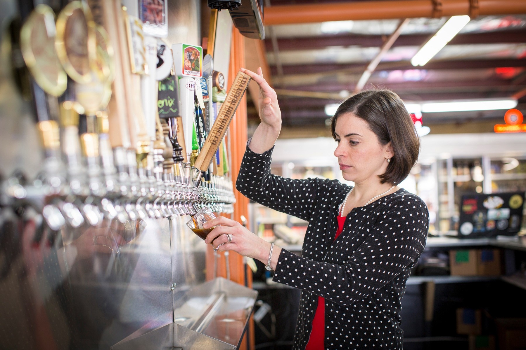 Julie Carvotta Bielecki operating a beer tap. 