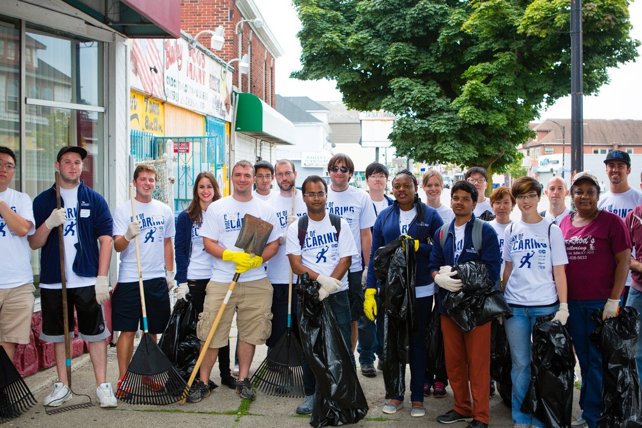 Students doing community work, cleaning up and planting a garden. 