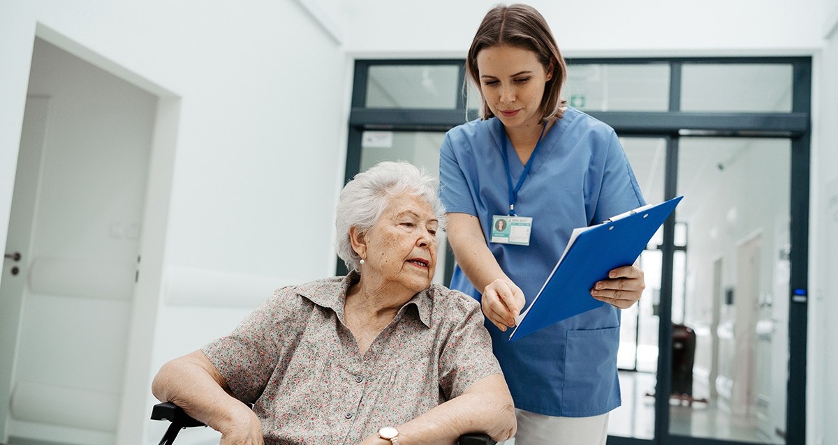Nurse talking with senior woman, discharging patient from hospital.