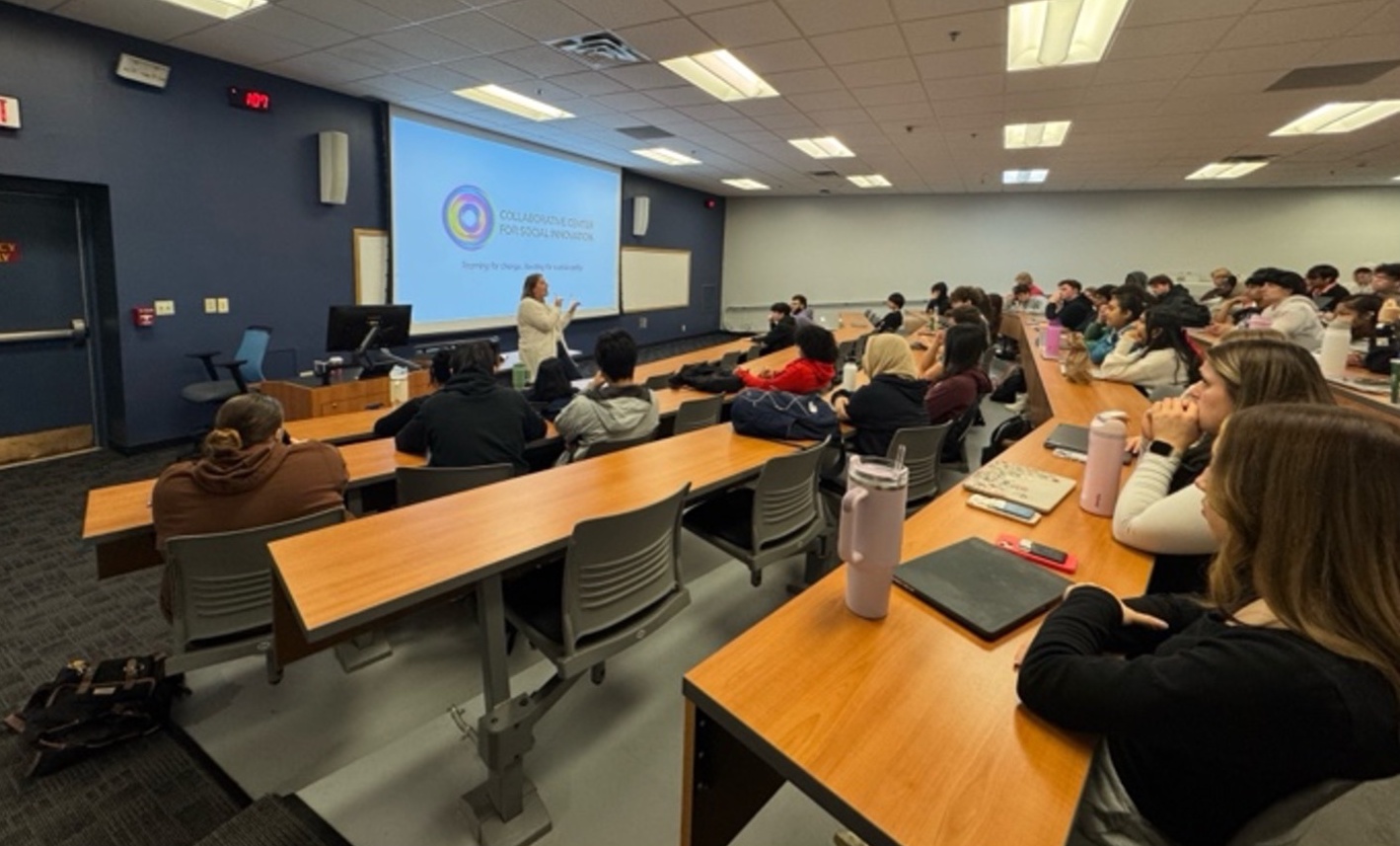 Students in a classroom listening to a professor. 