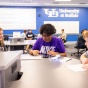 Three students work to solve a problem in a UB classroom. 
