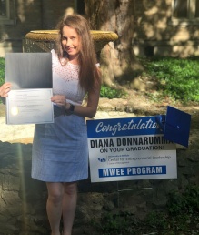 Donnarumma poses with her certificate of completion, graduation cap and a lawn sign congratulating her on graduating from the MWEE program. 