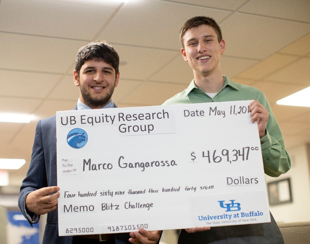 Zoom image: Gangarossa and fellow undergraduate Roderick Hughes, vice president of investments for the UB Equity Research Club, show off how much Gangarossa &quot;earned&quot; during the club&#39;s competition. Photo: Tom Wolf 