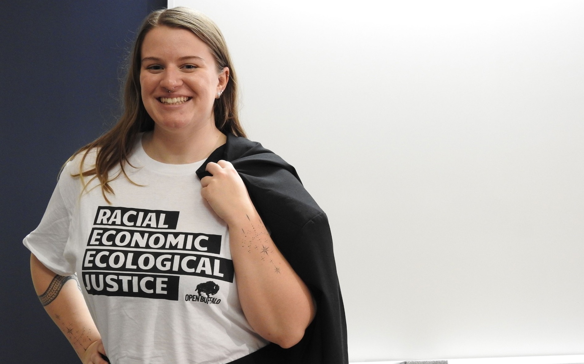 Student with a tee shirt that reads: Racial, Economic, Ecological Justice. 