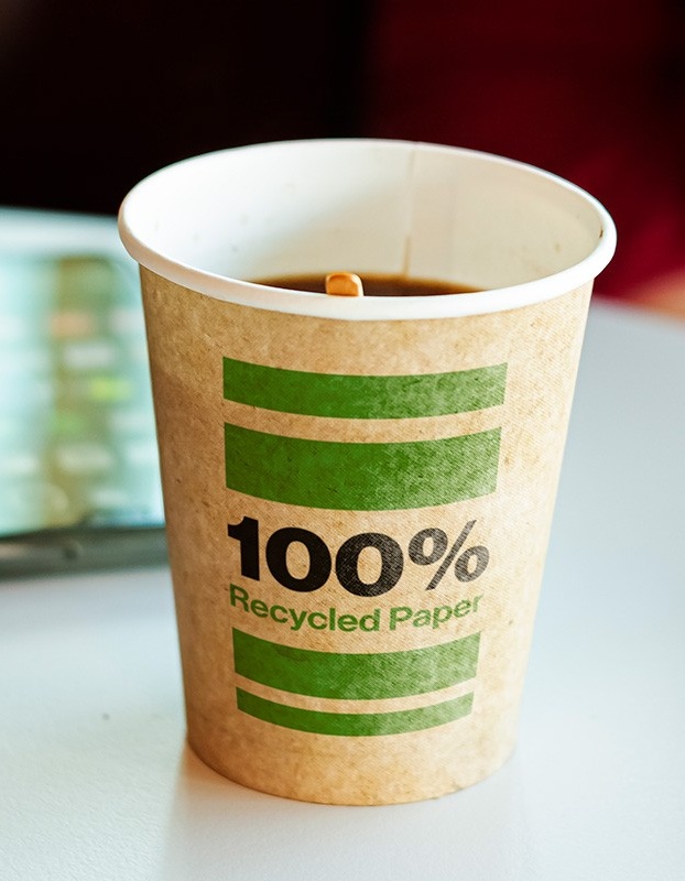 Coffee cup with text that reads 100% recycled paper. 