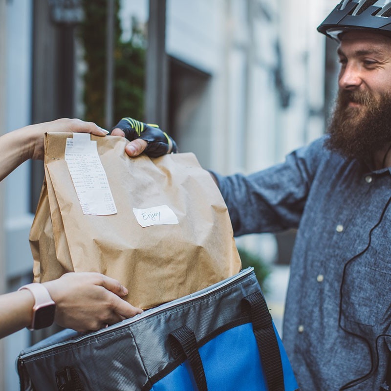 Person on a bike delivering a package. 