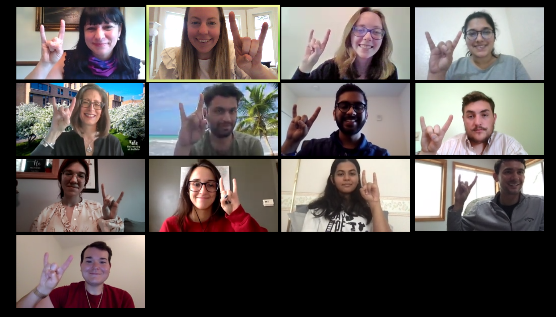 A Zoom screen with students and faculty displaying the "horns up" symbol with their hands. 