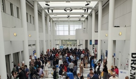 Large group of people lining up at tables or walking aroung the Management Career Expo at UB Center for the Arts. 