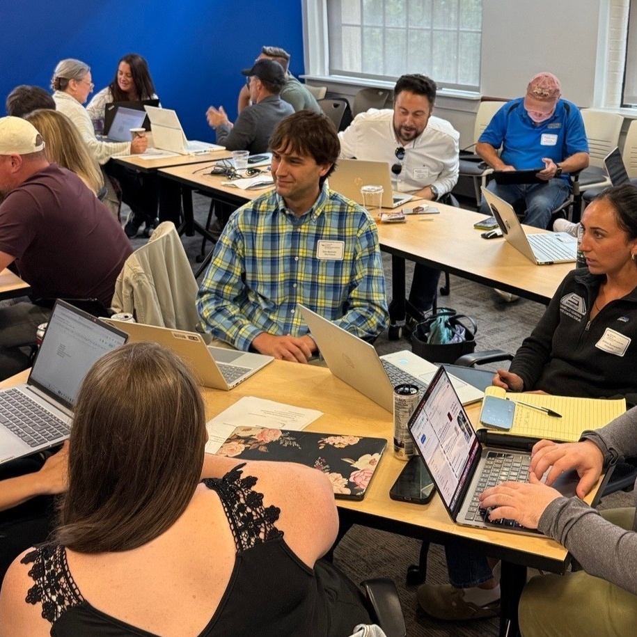 Group of people collaborating in a hands-on workshop setting. 