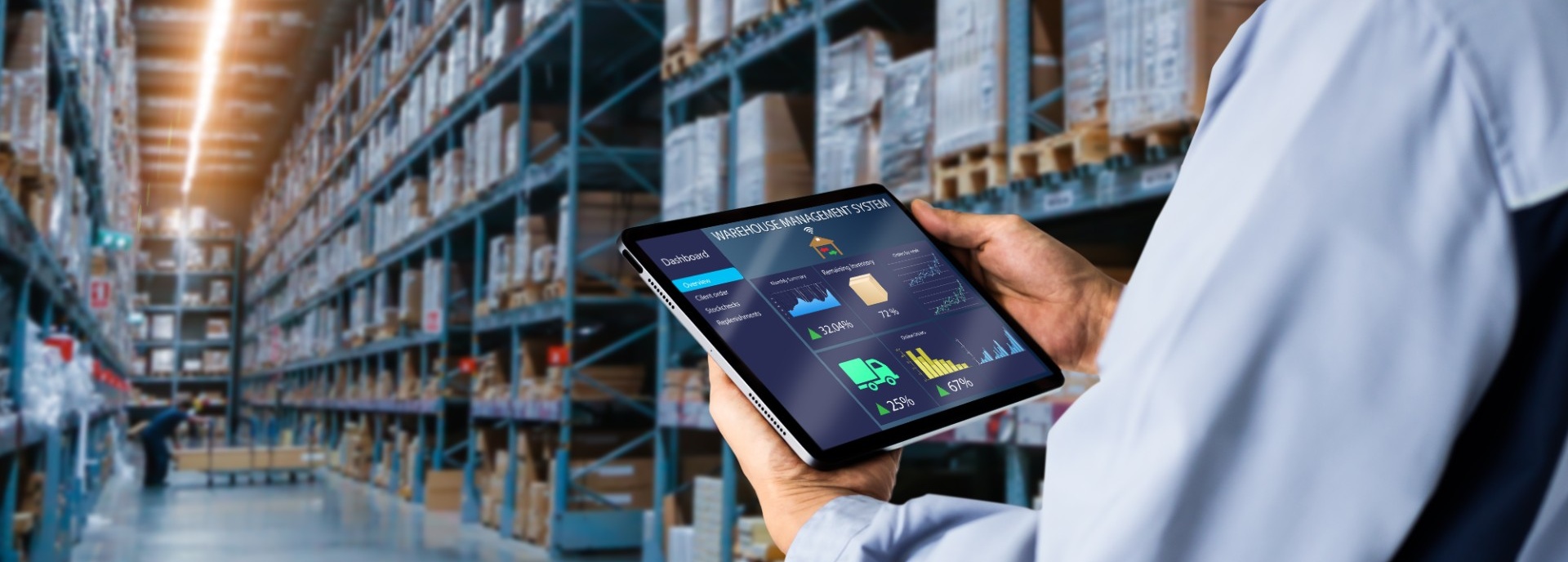 Person holding an ipad showing a dashboard while standing in a warehouse. 