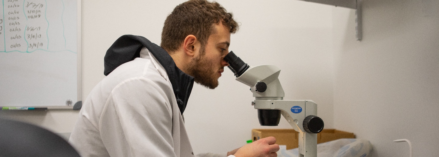 a student looking into a microscope. 