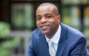 A student wearing a suit outside the Jacobs Management Center. 