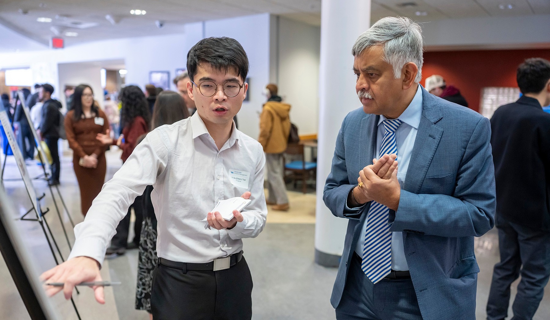 Dean Ananth Iyer listens as Yi Da (Edwin) Tsai explains his research at the 2025 PhD Showcase. 