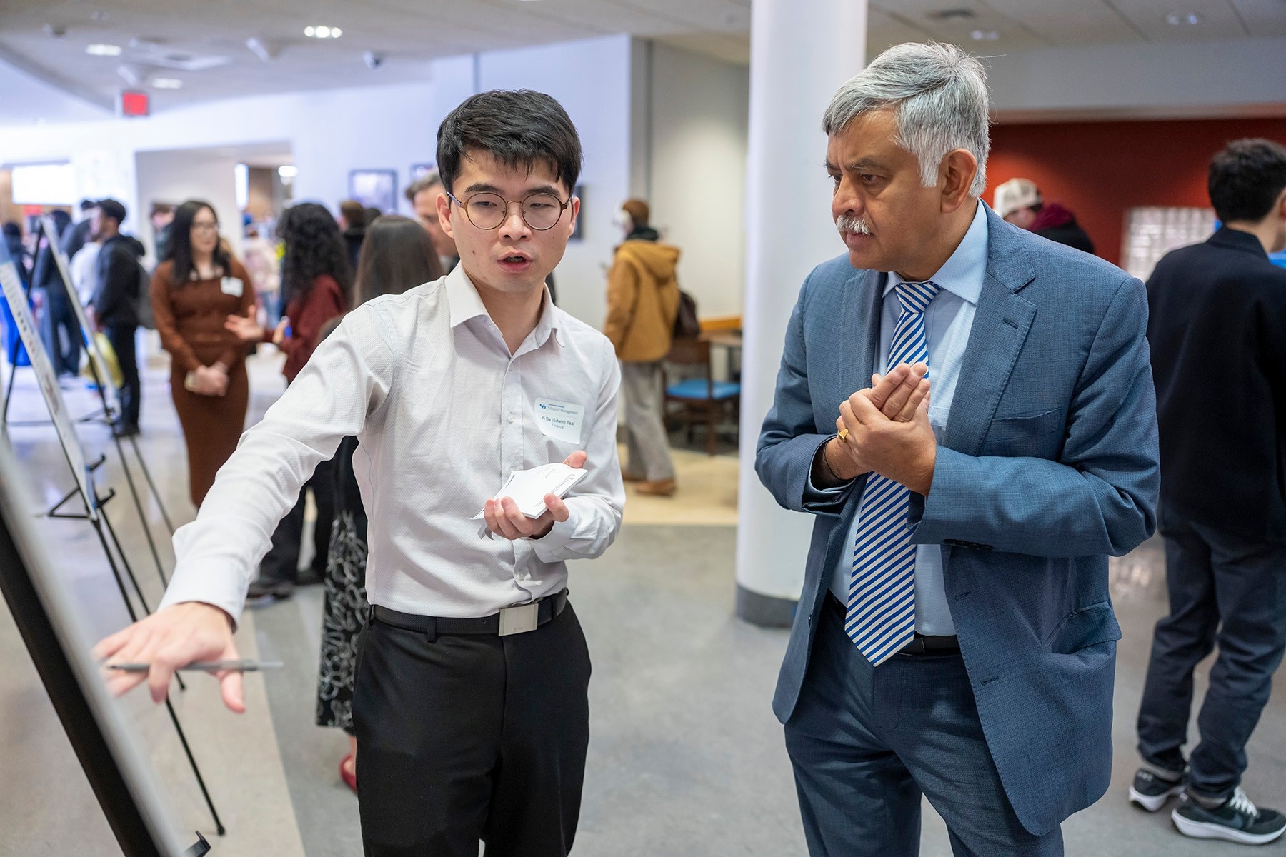 Dean Ananth Iyer listens as Yi Da (Edwin) Tsai explains his research at the 2025 PhD Showcase. 