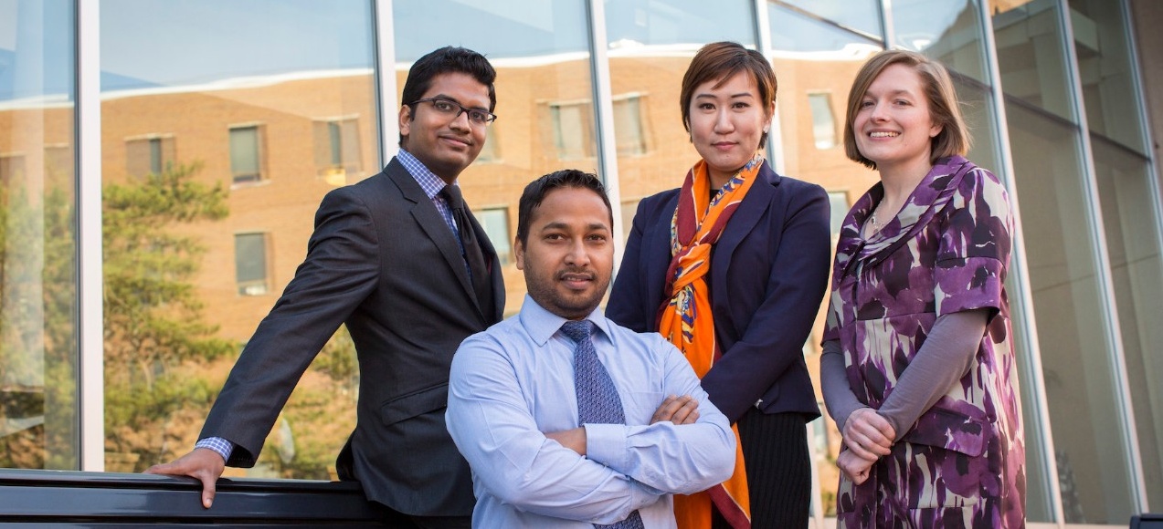 Four MBA students sitting outside of Alfiero Center. 