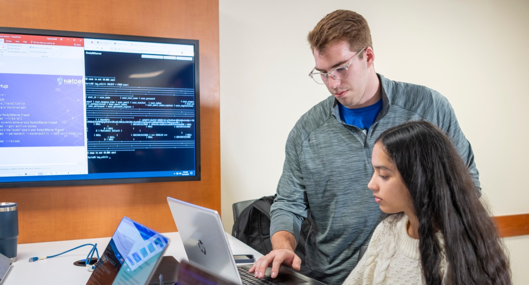 Female and Male MS in MIS students working together on a laptop. 