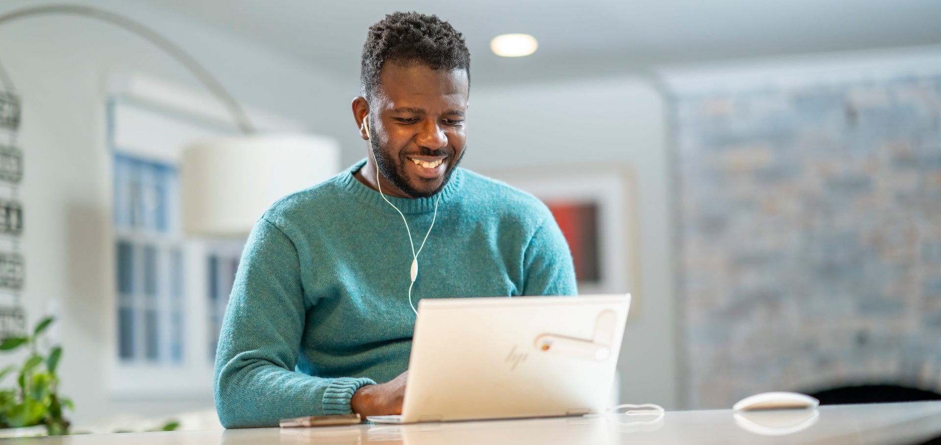 School of Management graduate student working on a laptop in a home.
