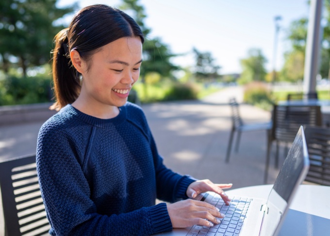 An MBA student using a laptop on the UB North Campus. 