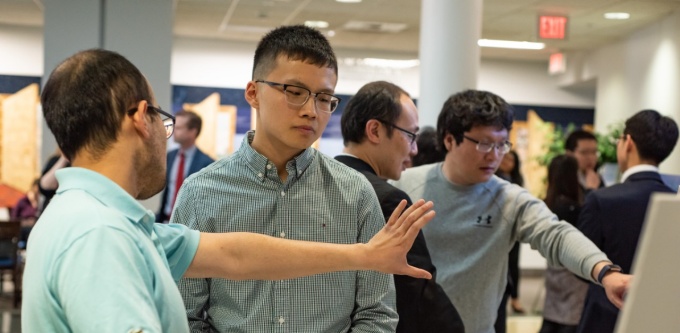 PhD student discussing his work at the PhD Showcase poster presentation. 