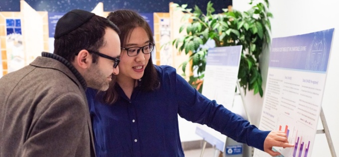 PhD in Management student discussing her research at the PhD Showcase poster presentation. 