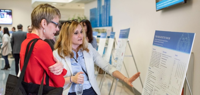 PhD in Management student discussing her research at the PhD Showcase poster presentation. 
