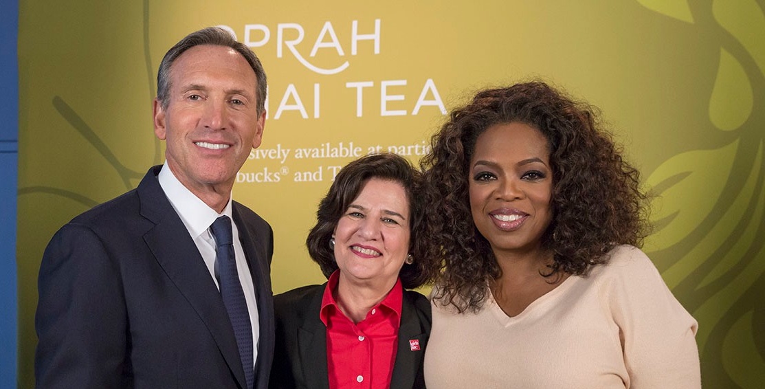 Alum in center of photo with former Starbucks CEO and media mogul Oprah Winfrey. 